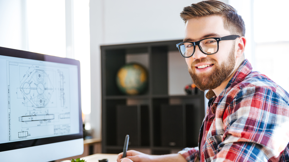 Das Bild zeigt einen Promotionsstudenten bei der Arbeit am Computer.