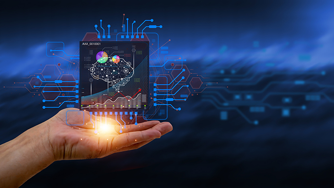 Eine Hand mit nach oben offener Handfläche, sie scheint eine Illustration eines Computer-Chips mit KI-Symbolen zu halten