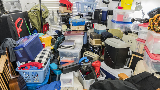 A room filled with furniture, boxes, and clutter