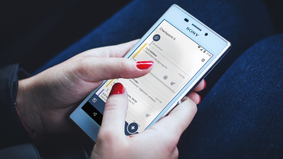 A women’s hands holding a mobile phone, the display shows content from the Checkpoint-S app